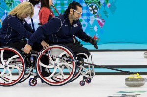 Jimmy Joseph, the team's Second, throws the stone for USA held by teammate Penny Greely.